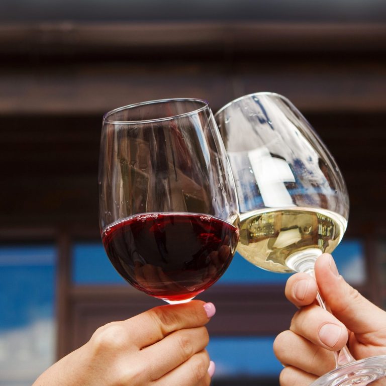 Es wird mt zwei Weingläsern angestoßen. 