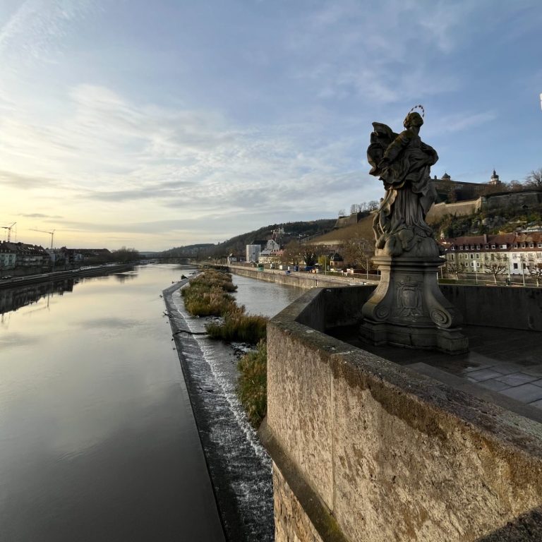 Winterlicher Blick auf Main, Steinstatue auf der Alten Mainbrücke und Festung Marienberg.